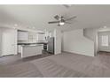 Open-concept living space with a ceiling fan and an adjacent kitchen with a center island at 6264 Blood Lily Ave, Las Vegas, NV 89122