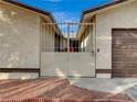 A white wrought iron gate sits between two beige walls of the home's courtyard at 6870 Laronda Ln, Las Vegas, NV 89156