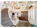 Grand foyer with a sweeping staircase, chandelier, and elegant decor at 7682 Calm Passage Ct, Las Vegas, NV 89139