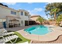 Backyard featuring a sparkling pool, hot tub, lounge chairs, and desert landscaping at 7682 Calm Passage Ct, Las Vegas, NV 89139