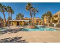 Community pool featuring a central island with palm trees, covered seating, and lounge space at 7950 W Flamingo Rd # 1081, Las Vegas, NV 89147
