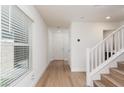 Inviting entryway with wood-look flooring, natural light from a window, and access to the staircase at 9099 Nostrand Ave, Las Vegas, NV 89148