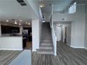 Open-concept interior with sleek flooring, stairs leading to the second story, and a kitchen area visible at 2504 Trustworthy Ave, North Las Vegas, NV 89031