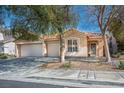 Inviting single-story home with a three car garage, tiled roof, and desert landscaping at 283 New River Cir, Henderson, NV 89052