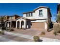 Two-story home with a two-car garage and a cozy front porch, complemented by well-maintained landscaping at 294 Dedication Ave, Henderson, NV 89011