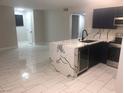 Bright, open-plan kitchen featuring marble floors, dark blue cabinets, and a marble countertop island at 2970 Juniper Hills Blvd # 102, Las Vegas, NV 89142