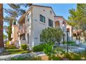 A condo building featuring stucco siding, dual paned windows, elevated access stairs and small garden area at 4861 S Torrey Pines Dr # 201, Las Vegas, NV 89103