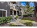 Condo building with green lawn, mature trees, and well-kept landscaping at 5250 S Rainbow Blvd # 2165, Las Vegas, NV 89118