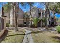 Exterior view of condo building surrounded by mature trees and well-maintained landscaping at 5250 S Rainbow Blvd # 2165, Las Vegas, NV 89118
