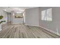Inviting living room boasts wood-look floors, access to the kitchen, and a sunlit window at 5250 S Rainbow Blvd # 2165, Las Vegas, NV 89118