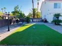 Beautiful backyard features an outdoor kitchen and a manicured lawn area perfect for entertaining at 5568 Yellow Ash St, Las Vegas, NV 89118