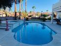 Relaxing backyard pool and spa with poolside lounge area surrounded by palm trees and lush landscaping at 5568 Yellow Ash St, Las Vegas, NV 89118