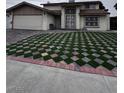 A beautiful front yard showcases its unique geometric grass design, leading to the home's entrance at 6775 Segura Dr, Las Vegas, NV 89103