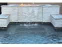 A luxurious pool water feature with a waterfall and fire feature at 7331 Abundant Harvest Ave, Las Vegas, NV 89131