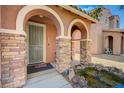 Covered porch with stone pillars and a decorative pond leading to the front door at 7815 Red Rock Ridge Ave, Las Vegas, NV 89179