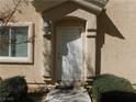 Charming front door with stone archway and manicured bushes at 8635 Tomnitz Ave # 103, Las Vegas, NV 89178