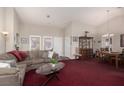 Bright living room featuring vaulted ceilings, large windows, and comfortable seating with a dining area at 8904 Marble Dr, Las Vegas, NV 89134