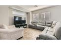 Bright living room featuring wood-look flooring, a comfortable sectional, and ample natural light at 9241 Placer Bullion Ave, Las Vegas, NV 89178