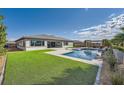 Inviting backyard with lush green grass, a sparkling pool, and a covered patio for outdoor living at 9475 W Rosada Way, Las Vegas, NV 89149