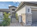 Close-up of the home's entrance featuring a modern gate, stone accents, and contemporary lighting at 9475 W Rosada Way, Las Vegas, NV 89149