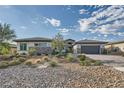 Charming home with desert landscaping, stone accents, and a spacious driveway leading to a two-car garage at 9475 W Rosada Way, Las Vegas, NV 89149