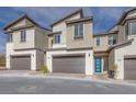 Charming home exteriors featuring modern design with stone accents, a front-entry garage, and a pop of color from the front door at 11940 Vector Ray Ave, Las Vegas, NV 89138