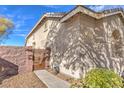 Exterior view of home with private gated courtyard and low maintenance desert landscaping at 258 Spring River Ave, Las Vegas, NV 89123