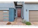 Modern townhouse entrance with a stylish door, two-car garage and landscaped walkway at 2699 Chance Canyon St, Henderson, NV 89044