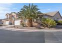 Single-story home with a two car garage, desert landscaping, and mature palm tree at 5600 Blue Peak Ave, Las Vegas, NV 89131