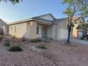 Quaint single story home with a two-car garage and desert landscaping at 6165 Highland Gardens Dr, North Las Vegas, NV 89031