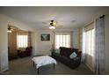 Comfortable living room featuring large windows, neutral tones, and two seating areas at 6437 Boatbill St, North Las Vegas, NV 89084