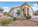 Charming home featuring desert landscaping, stone accents, and an arched entryway at 688 Quiet Stream Ct, Henderson, NV 89052