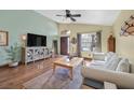 Bright living room with high ceilings, wood-look flooring, a ceiling fan, and stylish decor at 688 Quiet Stream Ct, Henderson, NV 89052
