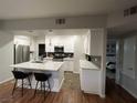 Open kitchen with white cabinets, a modern island and stainless steel appliances at 8250 N Grand Canyon Dr # 1036, Las Vegas, NV 89166