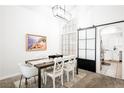 Dining area with modern table and chairs adjacent to kitchen with sliding barn door at 841 Glitter Glen Ct, Las Vegas, NV 89123