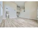 Bright living room featuring hardwood floors, soaring ceilings, a staircase, and neutral paint scheme at 9272 W Viking Rd, Las Vegas, NV 89147
