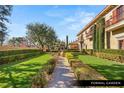 Lush formal garden with manicured hedges, mature trees, and a verdant lawn at 9940 Orient Express Ct, Las Vegas, NV 89145