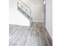 Living room with gray wood laminate flooring and staircase at 223 Greenbriar Townhouse Way, Las Vegas, NV 89121