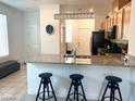 Bright kitchen features granite counters, stainless appliances, and breakfast bar with three stools at 2379 Albury Ave, North Las Vegas, NV 89086