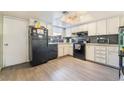 The kitchen features white cabinets, wood floors, and black appliances at 466 Las Casitas Way, Las Vegas, NV 89121