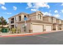 View of condo building exterior featuring garages and a red curb at 4720 Basilicata Ln # 101, North Las Vegas, NV 89084