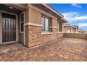 Covered front porch featuring stone accents and a brick-paved walkway to the front door at 741 Monroe Hill Pl, Henderson, NV 89011