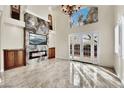 Elegant living room with marble fireplace, chandelier, and French doors at 9425 San Laguna Ct # 102, Las Vegas, NV 89134