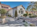 Beautiful house with a front yard landscaped with manicured bushes, stone, and mature trees at 9704 Brawley Dr, Las Vegas, NV 89134