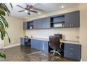 Spacious home office with built-in desk, storage cabinets, and hardwood floors, perfect for remote work at 9950 Waxberry Ct, Las Vegas, NV 89178