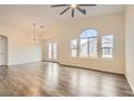 Bright living room with vaulted ceilings, wood floors, a ceiling fan, and large windows at 10147 Aspen Rose St # 101, Las Vegas, NV 89183