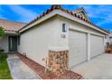 Close up of garage with stone detail on a home with a terra cotta colored roof at 1107 Cloudy Day Dr, Henderson, NV 89074