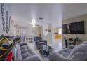 Open-concept living room with neutral tones, tile flooring, and modern furnishings at 320 Ellen Marie Dr, Las Vegas, NV 89110