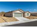 Single-story home with low maintenance desert landscaping and a spacious driveway leading to a two-car garage at 3924 E Garfield Dr, Pahrump, NV 89061