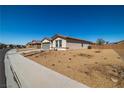 Desert-landscaped single-story home with a two-car garage, set against a clear blue sky in a neighborhood setting at 3924 E Garfield Dr, Pahrump, NV 89061